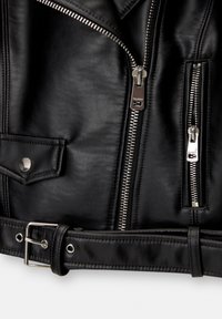 Veste en cuir noire avec fermetures éclair argentées, une poche pression et une ceinture avec boucle métallique en bas.