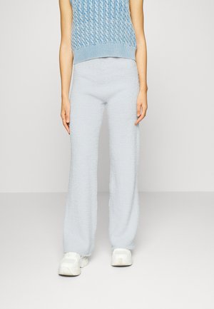 Calças largas em tricot fofas e azuis claras com uma textura suave, combinadas com uma blusa sem mangas em azul claro.