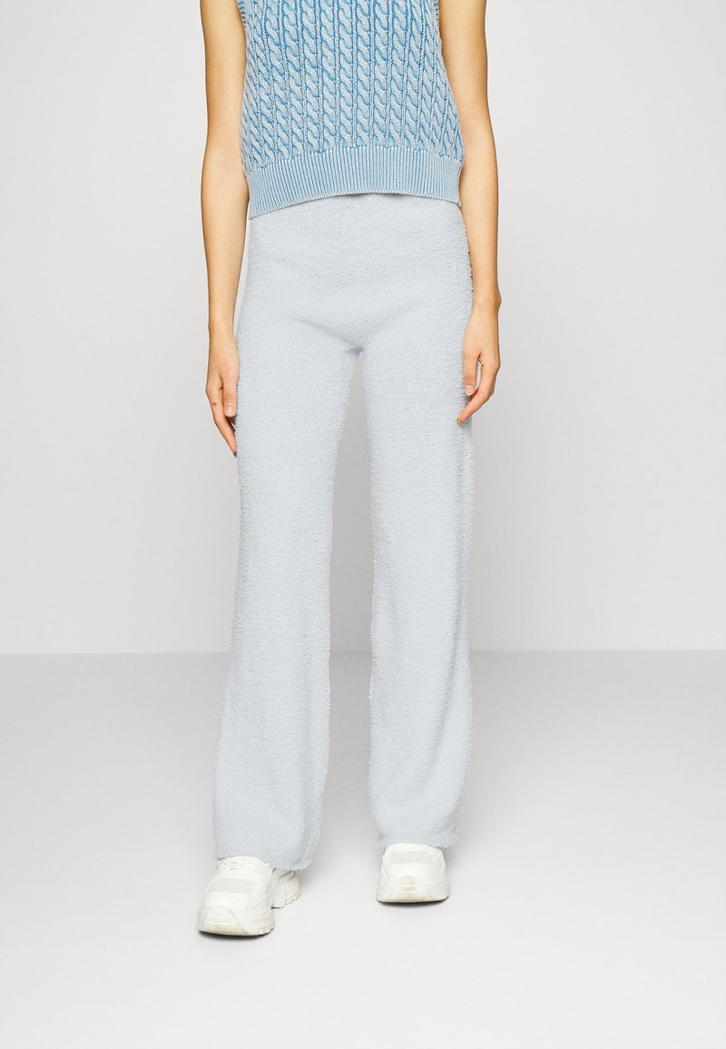 Calças largas em tricot fofas e azuis claras com uma textura suave, combinadas com uma blusa sem mangas em azul claro.