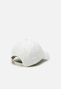 Gorra de béisbol de algodón blanca con visera curva, correa ajustable en la parte posterior y agujeros de ventilación. Presenta un logotipo grabado en la parte trasera.