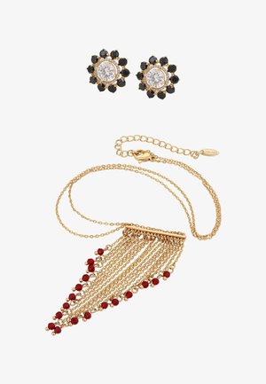 Collier chaîne en or avec des pampilles de perles rouges et des boucles d'oreilles clous en or ornées de pierres centrales claires entourées de pierres noires.