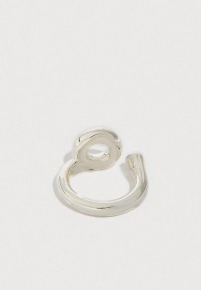 Bague en argent au design organique et torsadé. Texture lisse, avec une ouverture circulaire et un sommet arrondi. Forme minimaliste, finition polie.