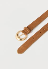 Ceinture en daim marron avec une boucle en métal doré arrondie et plusieurs trous d'ajustement sur un fond blanc.