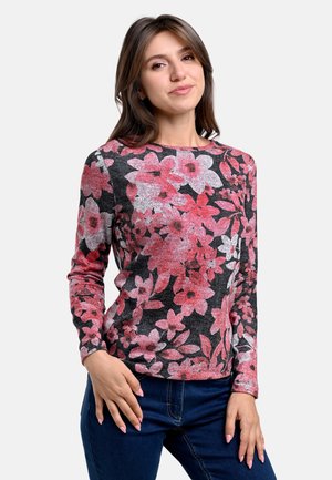 Langärmliges Sweatshirt mit floralem Muster in Schwarz mit Textur und rosa Blumen. Runder Halsausschnitt und taillierte Passform. Kombiniert mit blauen Jeans.