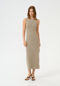 Ärmelloses beiges Strickkleid mit figurnaher Silhouette, das bis zur Mitte der Waden reicht, mit rundem Ausschnitt und dezenter Rippstruktur.