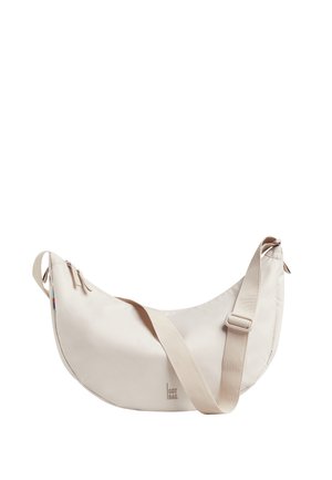 Beige skuldertaske formet som en halvmåne med justerbar rem, lynlåslukning og lille "GOT BAG"-logo på forsiden nederst i midten.