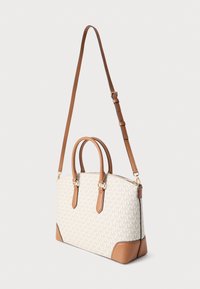 Τσαντάκι tote με μονογράμμο σχέδιο σε κρεμ ύφασμα, λεπτομέρειες από καφέ δέρμα, διπλές λαβές στο πάνω μέρος και ρυθμιζόμενο λουρί ώμου.