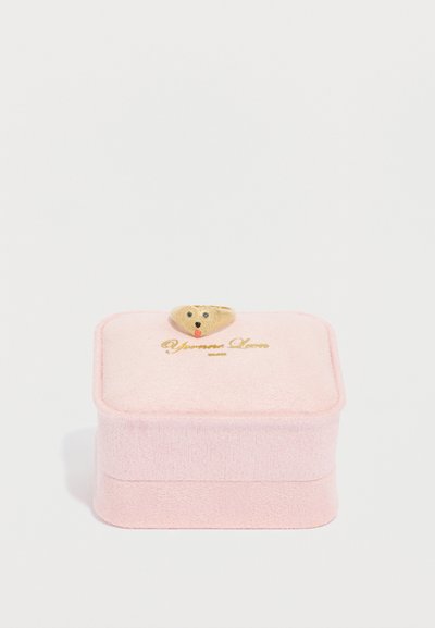 Ružová šperkovnica s mäkkou, textúrovanou tkaninou, ozdobená roztomilým viečkom v tvare medvedíka a zlatým logom na prednej strane.