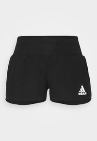 Mustat Adidas-urheiluhousut, joissa on leveä vyötärö ja valkoinen Adidas-logo oikeassa etujalassa.