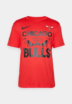 Red cotton t-shirt featuring black graphic text "CHICAGO BULLS" and logo. Short sleeves, crew neck, and soft texture.