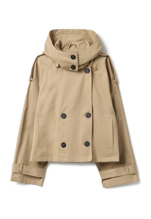 Chaqueta beige de doble botonadura con capucha ancha, grandes botones negros, hombreras y mangas estructuradas. Textura similar al algodón.