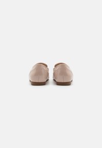 Ballet flats in lichtroze gepatineerd leer met een gladde textuur, ronde neus en kleine bruine hak. Eenvoudig en klassiek ontwerp.