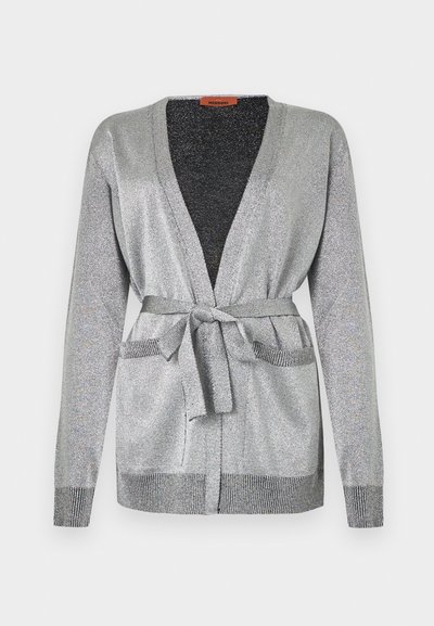 Ασημένια μεταλλική ζακέτα με μακριά μανίκια, δύο μπροστινές τσέπες και ταιριαστή ζώνη δεμένη στη μέση, με ριμπ μανσέτες και τελείωμα.