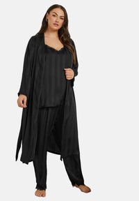 Svart satin pyjamas-set som består av en lång robe, en cami-top med spetsdetaljer och randiga byxor med spetskanter. Mjuk textur, avslappnad passform.