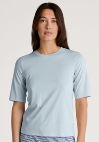 Lichtblauw t-shirt met korte mouwen en ronde hals, zachte textuur en ontspannen pasvorm; de stof lijkt zacht en licht rekbaar.