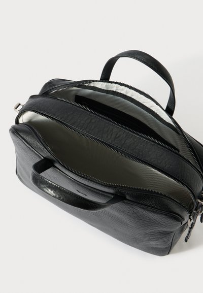 Fekete bőr táska texturált felülettel, két cipzáras rekesszel és egy felső fogantyúval, csíkos bélés belsővel.