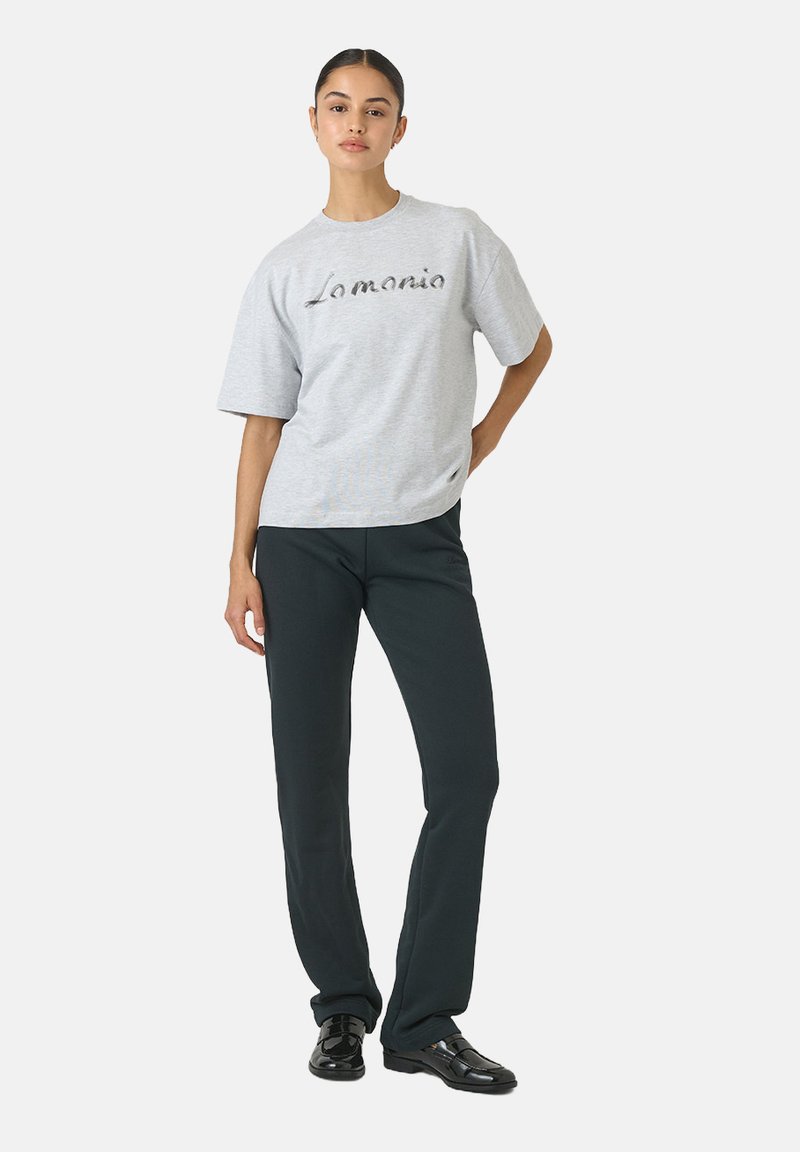 Sivý bavlnený tričko s krátkymi rukávmi a zaobleným výstrihom, so štýlovým čiernym logom. V kombinácii s čiernymi slim-fit nohavicami a obuvou.