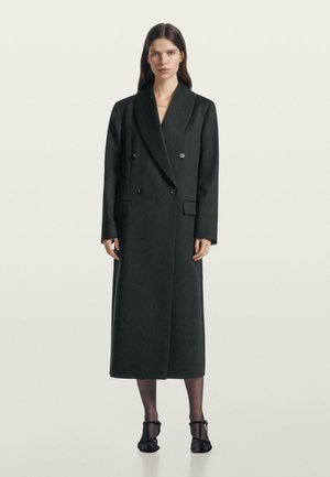 Cappotto lungo, grigio scuro, a doppio petto con colletto a punta, tasche laterali e taglio dritto, realizzato in un tessuto testurizzato.