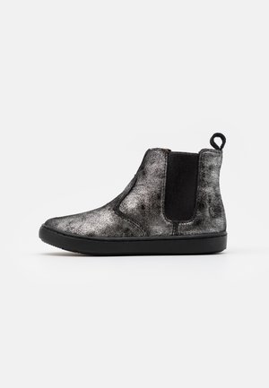Botte Chelsea noire et grise tachetée avec panneau latéral élastique, semelle noire et languette sur fond blanc.