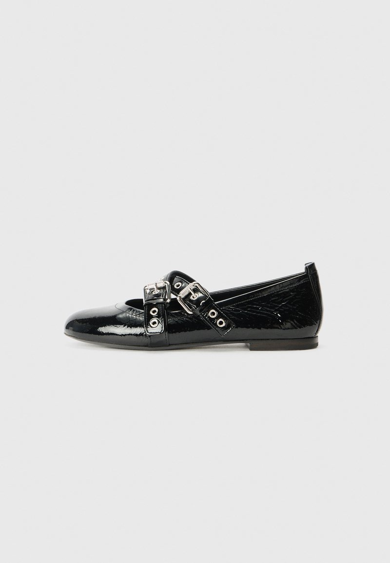 Black patent leather flats featuring a rounded toe and decorative straps with silver hardware. The design includes a low profile and smooth texture.