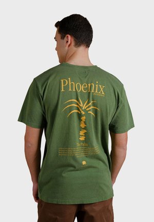 Groene t-shirt met korte mouwen, met een gele palmbomengrafiek en tekst op de achterkant, met een relaxte pasvorm en zachte textuur.
