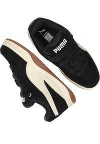 Sneaker in suede nera con striscia laterale crema, dotate di suola in gomma testurizzata e linguetta con marchio. I lacci sono intrecciati e spessi.