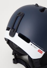 Marinehjelm med matt finish, hvit aksent, ventilasjonsåpninger, justerbare stropper og merkevaredetaljer for NFC Medical ID og RECCO.