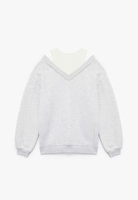 Grå sweatshirt med V-urringning och nedhasade axlar, lager på lager över en vit polokrage-topp. Blandning av bomull med en mjuk yta.