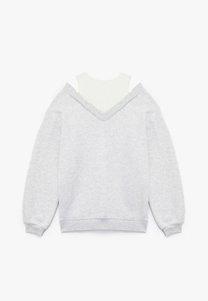 Gray sweatshirt with a V-neck and drop shoulders, layered over a white mock neck top. Cotton blend material with a soft texture.