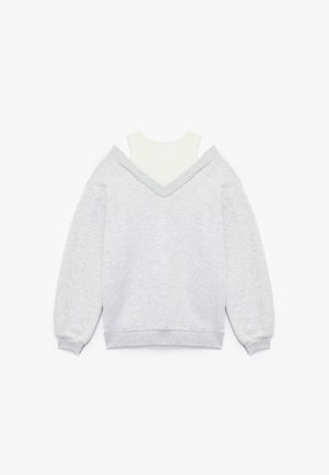 Grijze sweatshirt met een V-hals en drop shoulders, gelaagd over een witte mock neck top. Katoenmix materiaal met een zachte textuur.