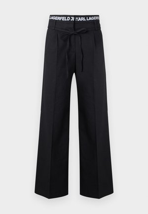 Črne široke hlače z zavezanim pasom in modnim pasom z napisom "KARL LAGERFELD" v belem tekstu.