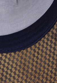 Sombrero tipo bucket de poliéster con un patrón a cuadros en azul oscuro y dorado, con un tejido texturizado y una banda azul sólida.