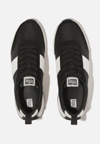 Zwart-witte sneakers met een gestructureerde bovenkant, voorzien van een opvallende witte streep, ronde neus en zwarte veters, ontworpen voor comfort.