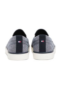 Platnene slip-on cipele u tamnoplavoj i srebrnoj boji sa teksturiranim dizajnom, koje sadrže kontrastnu tamnoplavu pozadinsku prugu i mali akcent logotipa.