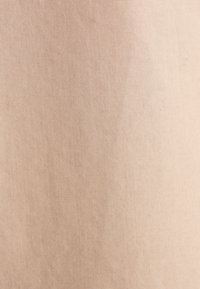 Tessuto di cotone beige chiaro con una texture liscia e una leggera lucentezza, che presenta un motivo uniforme senza dettagli o accenti visibili.
