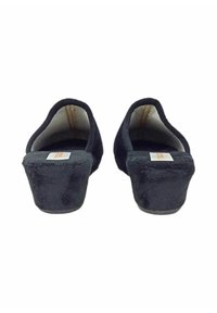 Pantofole nere in peluche con tacco basso a zeppa e design con apertura sul retro. Texture morbida, linee semplici e branding minimo visibile sulla soletta.