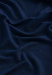 Material moale, de culoare albastru închis, cu o textură netedă, având pliuri și cute blânde, care indică flexibilitate și capacitate de a se drapa.