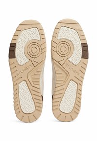 Sneaker beige con suole in gomma testurizzata caratterizzate da un elemento di design circolare e dalla marcatura "HILFIGER". Dettagli in colore marrone.