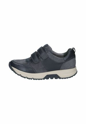 Donkergrijze sneaker met twee klittenbandsluitingen, dikke lichtbeige zool en een gestructureerde zwarte loopzool, zijaanzicht op witte achtergrond.