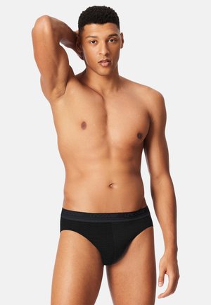Slip da uomo nero con design in mesh strutturato e una cintura nera a contrasto con il marchio "uncover".