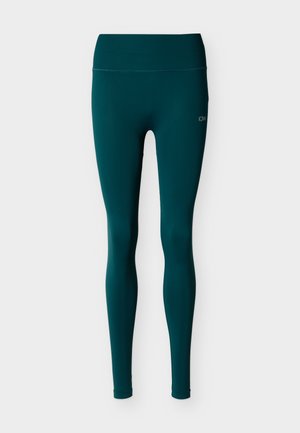 Leggings taille haute couleur sarcelle foncée avec une large ceinture côtelée et un petit logo blanc "ICIW" sur la cuisse gauche supérieure.