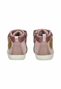 Růžové semišové vysoké boty s jemnou texturou, bílé gumové podrážky, boční zipy a hnědý květinový akcent na zadní straně.