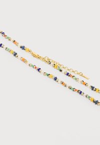 Κολιέ με μικρές στρογγυλές χάντρες σε διάφορα χρώματα και υφές, με κούμπωμα αλυσίδας από χρυσό και ρυθμιζόμενους κρίκους.