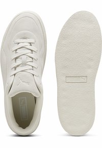 Bijele suede tenisice s teksturiranom potplatom, s dizajnom na vezivanje, podstavljenim ovratnikom i malim Puma logotipom na jeziku.