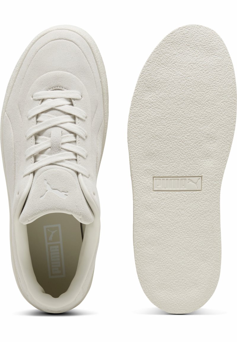 Sneakers bianchi in suede con suola texturizzata, caratterizzati da un design con lacci, collo imbottito e un piccolo logo Puma sulla linguetta.