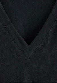 Czarny t-shirt z dekoltem w kształcie litery V, wykonany z teksturowanej tkaniny, z głębokim, skośnym dekoltem oraz subtelnym przeszyciem wzdłuż krawędzi.