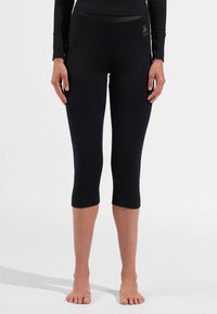 Leggings capri noirs en matière extensible, avec une texture lisse et un accent de logo près de la taille.