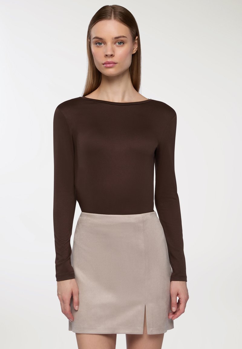 Brązowa bluzka z długim rękawem i dekoltem w łódkę, zestawiona z jasnobeżową mini spódnicą z przodem rozciętym i miękką, gładką fakturą.