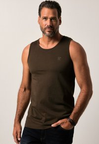 Mørkebrun tanktop med rund hals, lavet af blødt bomuld. Har et subtilt logo i øverste venstre hjørne. Simpelt design, uden ærmer.