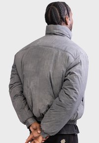 Gray puffer jacket with a high collar and ribbed cuffs. The fabric has a textured finish, featuring a loose fit and dropped shoulders.